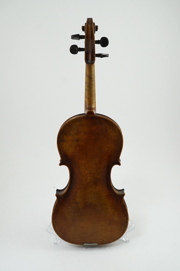 A late 19th century German Nuremberg school violin c.1880, Stradivarius pattern with a finely carved scroll and a large 14.25 inch body, together with a fully mounted German octagonal bow, contained within a contemporary